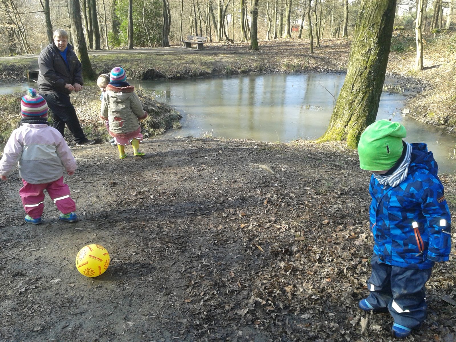 Kinder spielen gemeinsam draußen in der Natur am Wasser